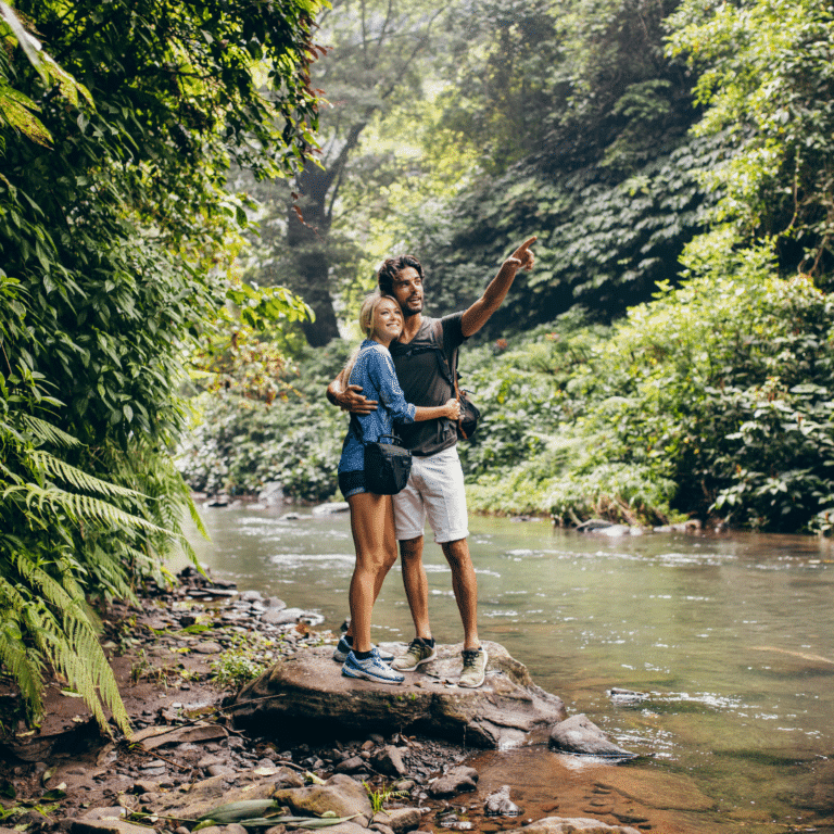 Couple explorant une forêt tropicale près d'une rivière.