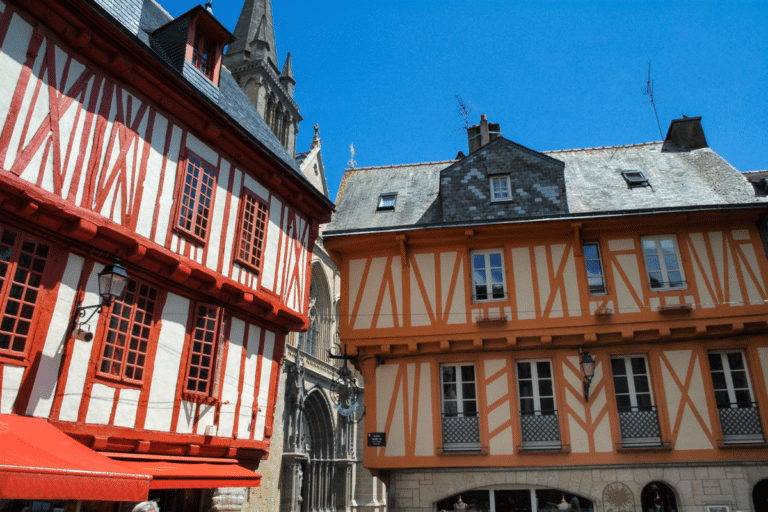 Maisons à colombages, église et ciel bleu en Bretagne.